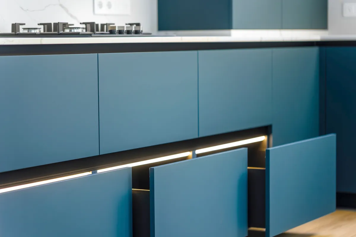 Refinished base cabinets in a matte blue with the original carcasses kept in place.