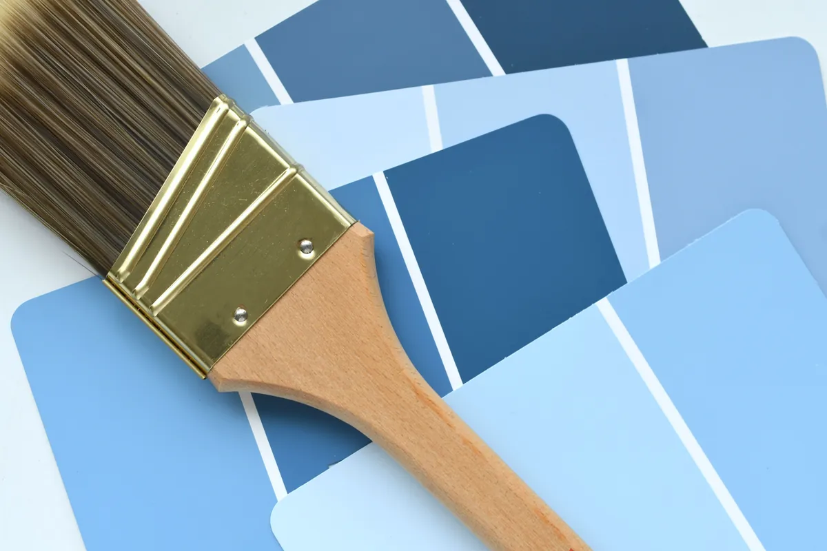 Brush resting on a set of blue colour swatches during a colour consultation.