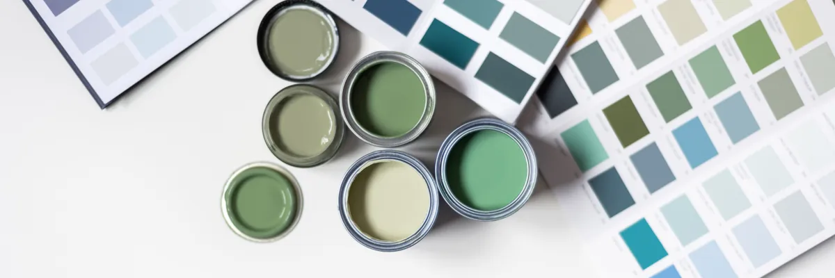 Sample pots and colour charts laid out while choosing a wall colour.