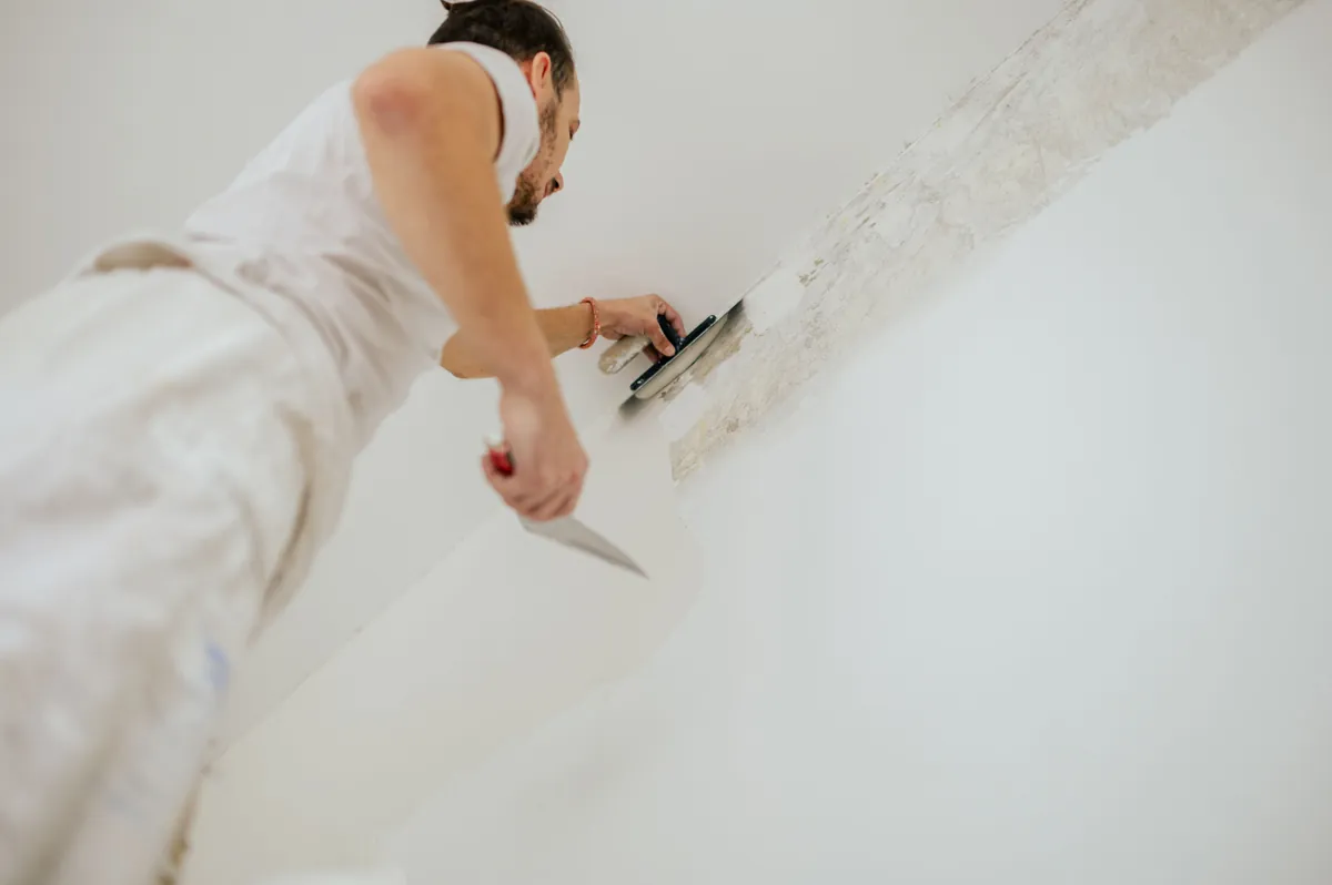 Skim coat being worked across a wall to level it before painting.