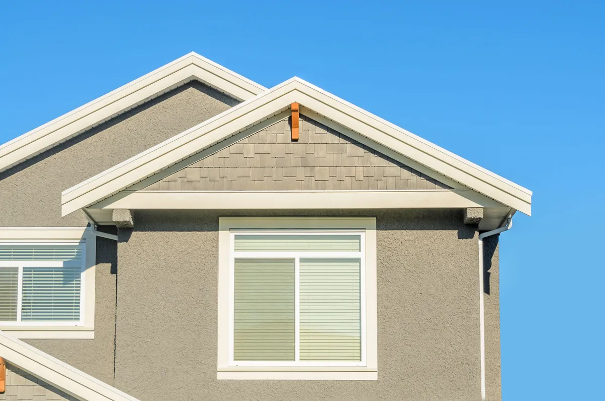 Exterior repaint on a two-storey house, body in grey with white trim and fascia.