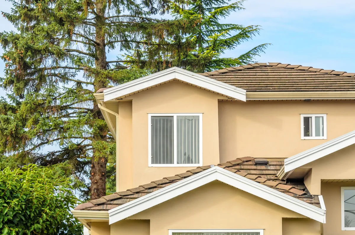 Two-storey stucco exterior finished in a warm tan with the trim picked out in white.