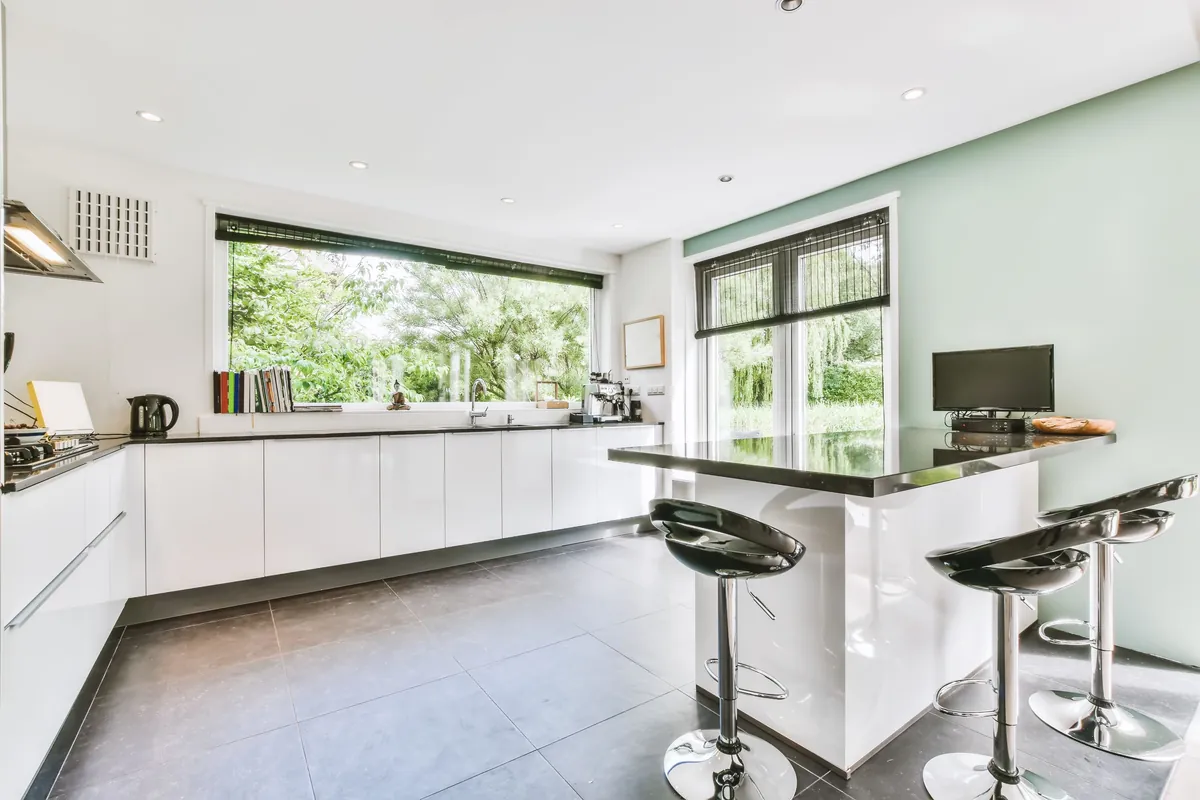 Finished interior in a large kitchen, walls and ceiling in a flat white with dark painted trim.