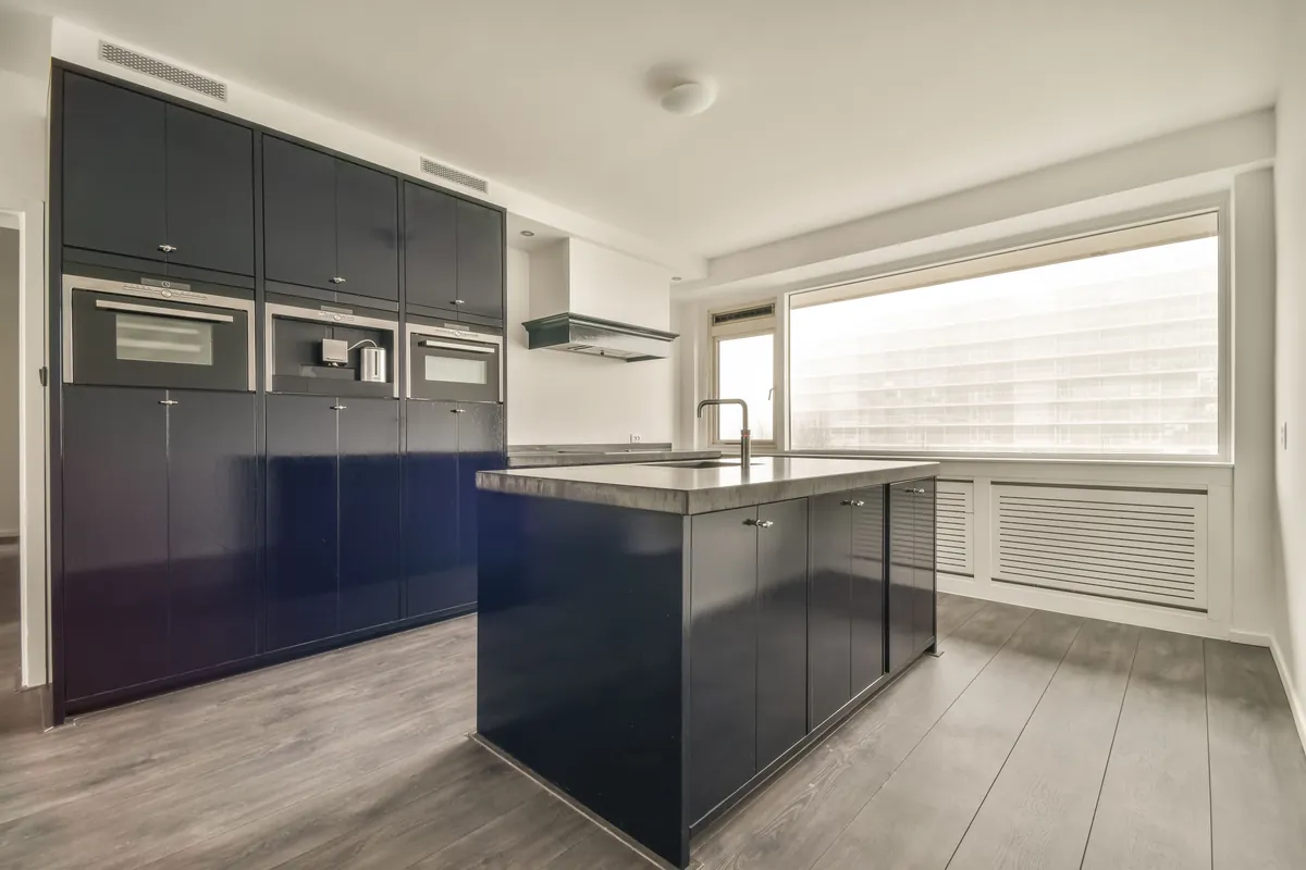 Interior painted around a kitchen island and a tall window, cut in cleanly at the frame.