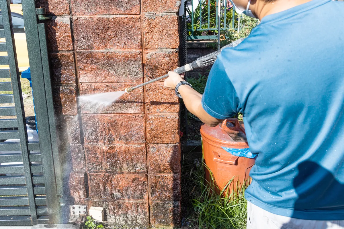 Wall being washed down with a pressure washer before any coating goes on.