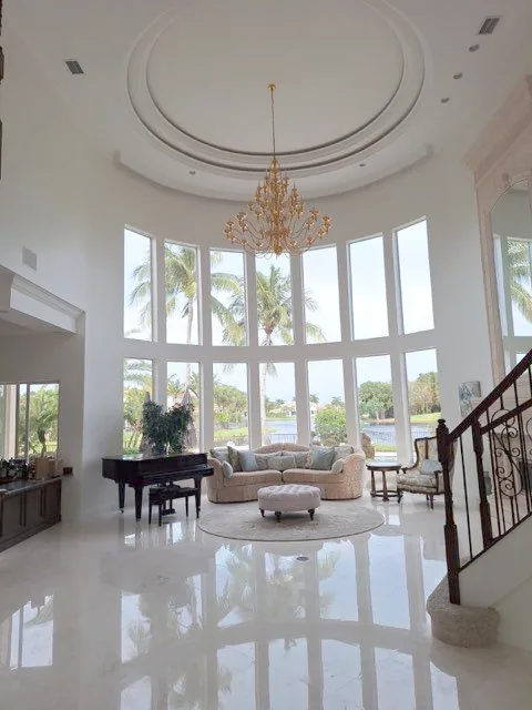 Great room with a two-storey window wall, white painted walls and a domed ceiling with a chandelier.